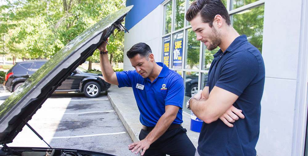 NAPA Employee with customer under hood.